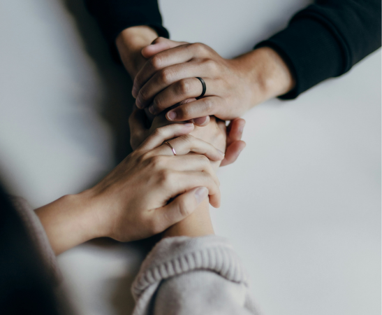 The hands of two people clasping, as if having a heart to heart